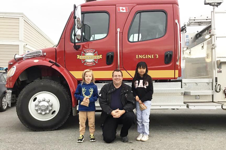 Ashcroft Fire Rescue chief Josh White (c) with 'Fire Chiefs for a Day' Mack Lysyshyn (l) and Tasia Antoine.