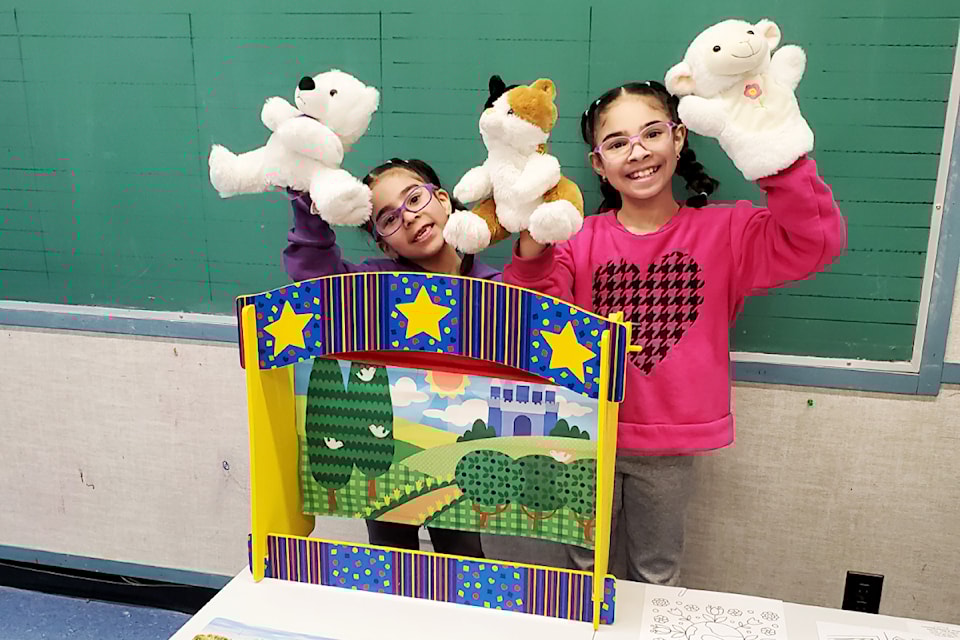 Alondra Urribarri (l) and her sister Arianna have fun with some puppet play during a Family Literacy Week event at the Ashcroft HUB on Jan. 29.