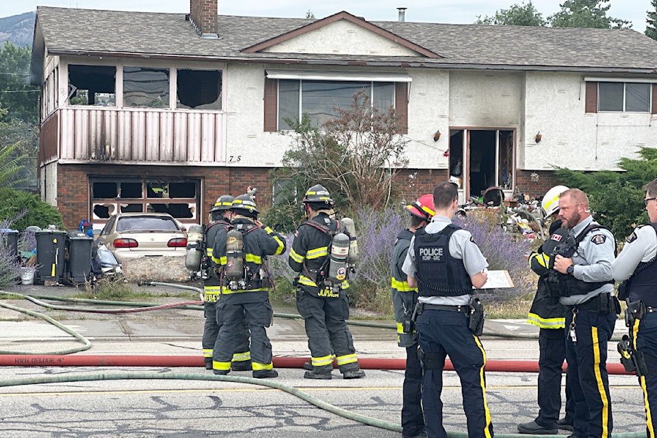 Firefighters and police outside the scene of a house fire in 鶹AV's Rutland area on Sunday, July 27.