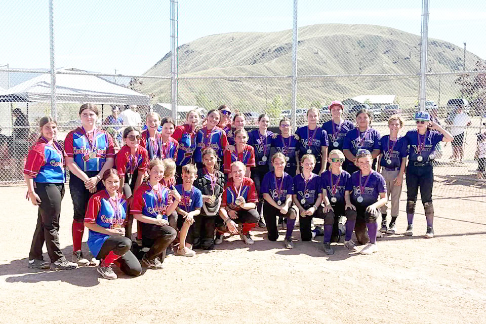 The Cache Creek Chaos U-13 girls' team (red and blue uniforms at left) celebrate their gold medal win at the Desert Heat softball tournament in Ashcroft on the weekend of June 6. Vernon Vortex (r) took the silver medal.