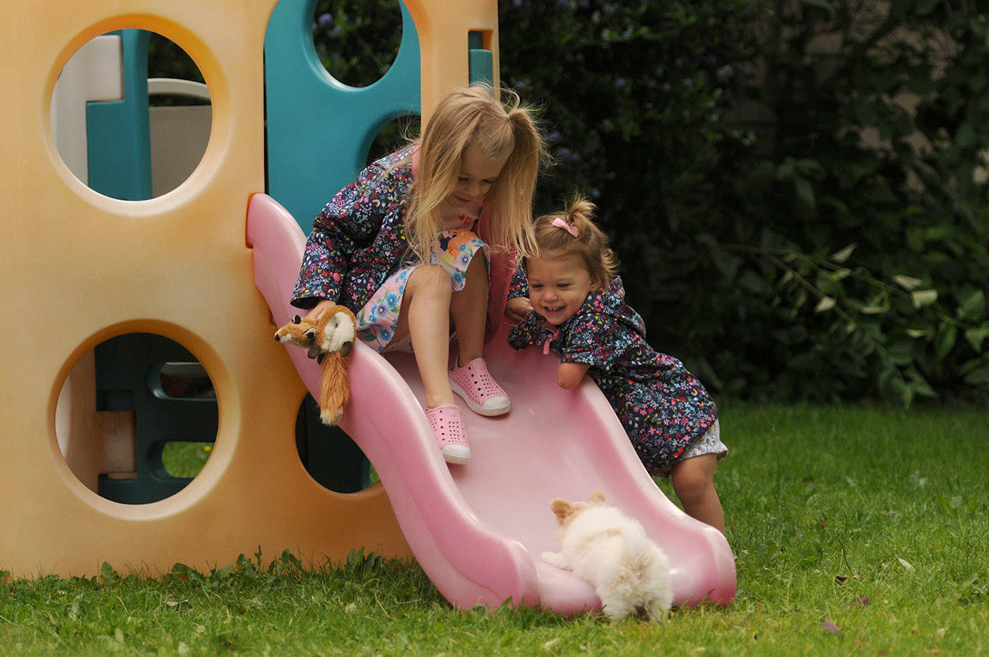 Two-year-old Ivy McLeod and five-year-old sister Elena play with Lucky the puppy outside their Chilliwack home on Thursday, June 10, 2021. (Jenna Hauck/ Chilliwack Progress)