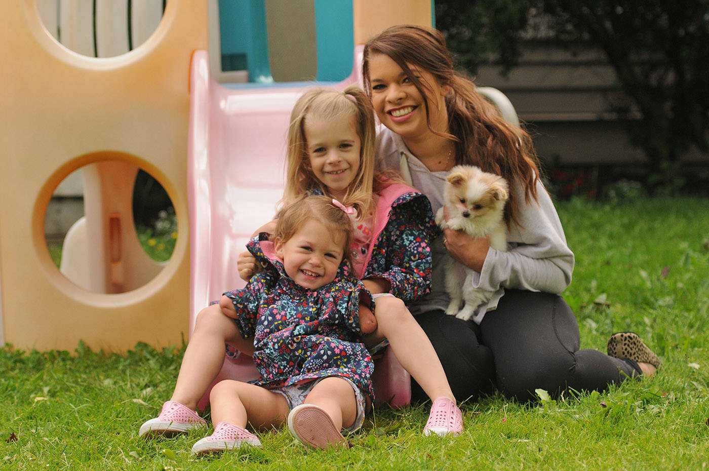 The McLeod family – Ivy, 2, Elena, 5, and mom Vanessa – are seen with their new puppy Lucky outside their home in Chilliwack on Thursday, June 10, 2021. Not pictured is husband/dad Sean McLeod. (Jenna Hauck/ Chilliwack Progress)