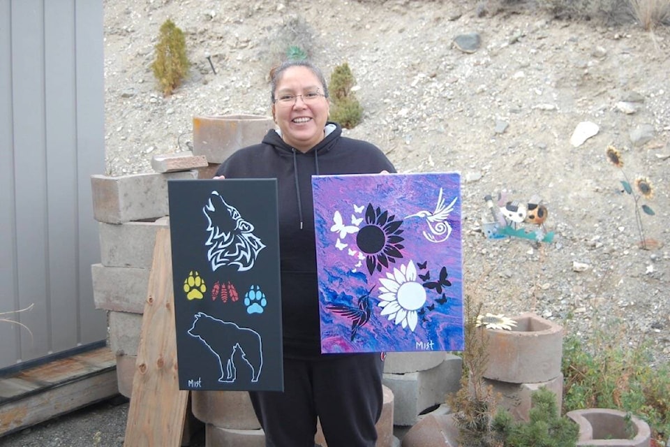 Artist Misty Antoine with two of her pieces. She will have more of her artwork on display, and for sale, at a First Nations craft fair in Cache Creek on Nov. 27. (Photo credit: Barbara Roden)