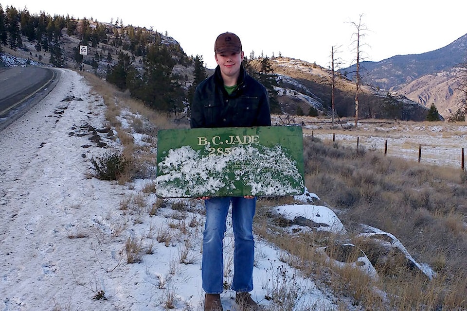Rylan Roy with the jade boulder sign near the site where it was found beside Highway 1. (Photo credit: Heidi Roy)