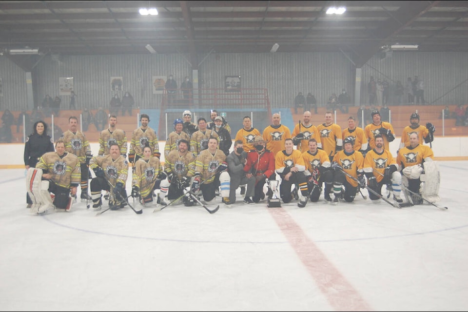 The teams for the First Responders Charity Hockey Match on Jan. 22 gather at centre ice after the game. (Photo credit: Barbara Roden)