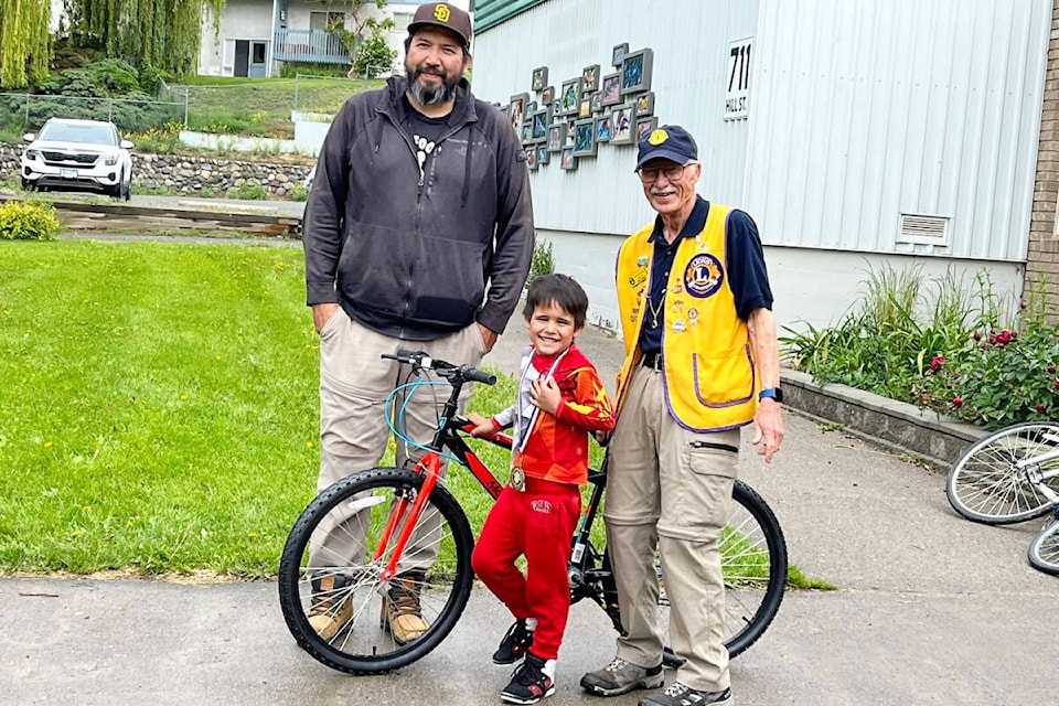 Benjamin Pierro (centre), who took part in this year’s Skip’s Run, was the winner of a bike donated by Lion Nick Lebedoff (r). Also pictured is Benjamin’s dad, Brad. (Photo credit: Kimberly Pierro)