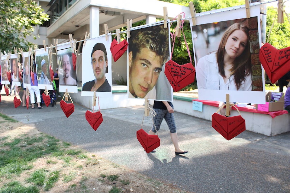 Photos of loved ones outside the Ministry of Health office during an International Overdose Awareness Day event in Victoria. (Jake Romphf/News Staff)
