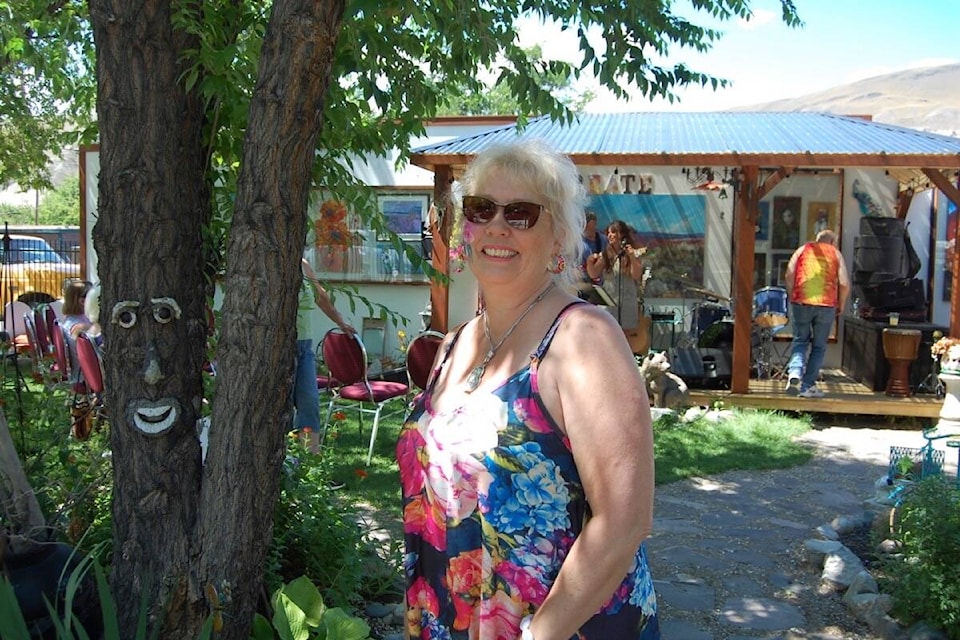 Marilyn Anderson in the art courtyard in July 2022, with the bandstand and Elephant Mountain painting behind her. (Photo credit: Barbara Roden)