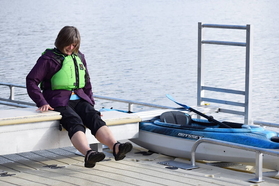 Ruth Campbell starts the demonstration process of sliding down the graduated bench to access the kayak in its roller ramp at the new accessibility dock installed at Legion Beach in Quesnel. (Tracey Roberts photo - Quesnel Cariboo Observer)