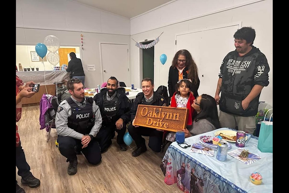 RCMP officers and Hereditary Chief Helen Michelle with Oaklynn Schweder and her parents. 