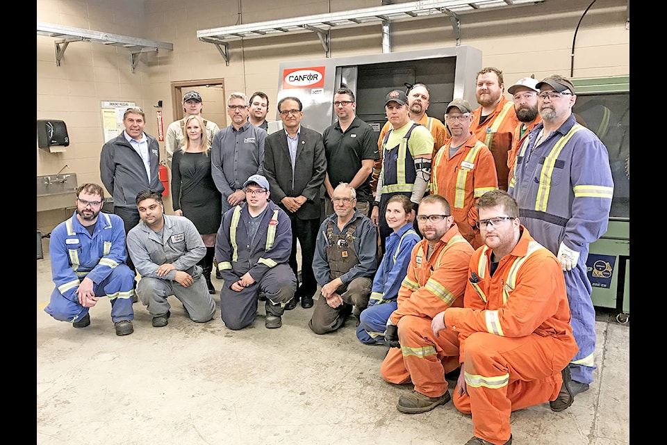 Thompson Rivers University Williams Lake Campus staff, forest industry representatives and students gather Monday to acknowledge the donation of a new piece of equipment for the Saw Filing Apprenticeship Program, thanks to Canfor and HMT Machine Tools Canada. (Angie Mindus photo)