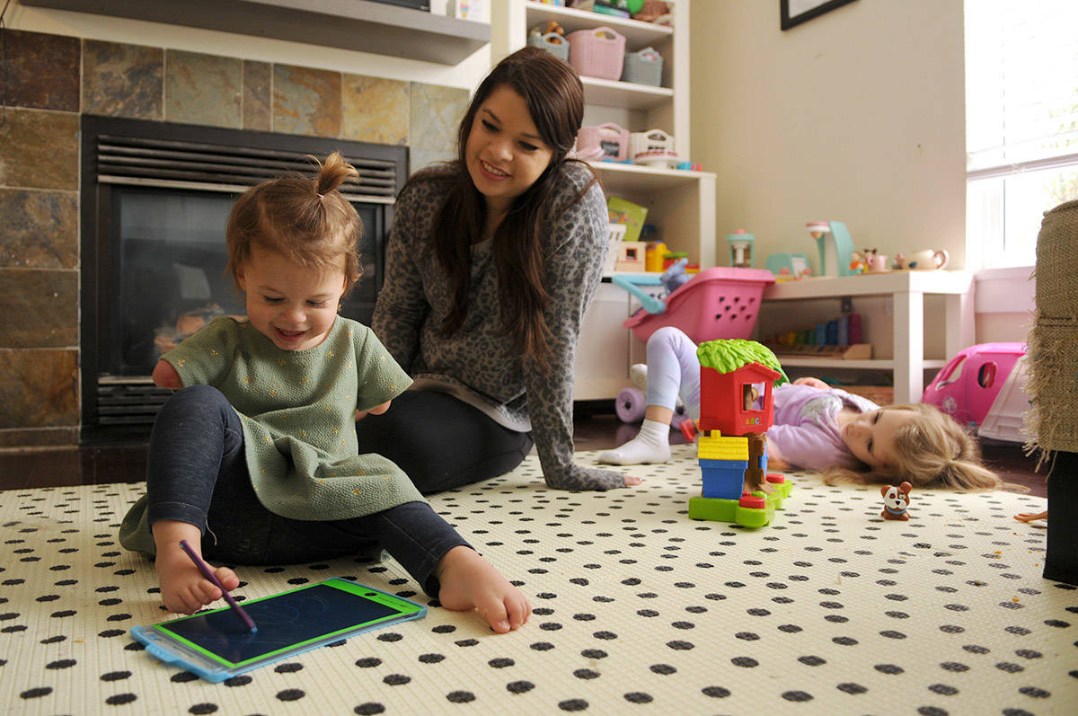 Two-year-old Ivy McLeod, seen here on April 9, 2021 with four-year-old sister Elena and mom Vanessa, was born with limb differences. The family, including husband/dad Sean McLeod, is looking for a family puppy that also has a limb difference. (Jenna Hauck/ Chilliwack Progress)