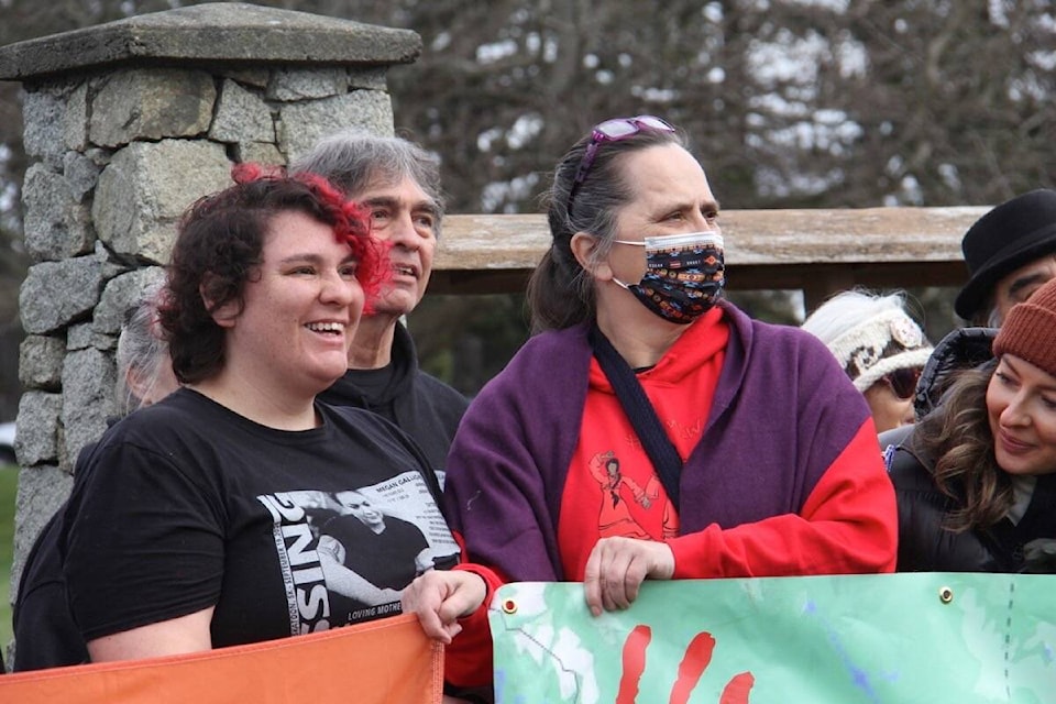 Krista Fox, right, Lindsey Bishop and a large group of supporters gather for a group photo before walking to the legislature in Victoria. (Christine van Reeuwyk/ Staff)