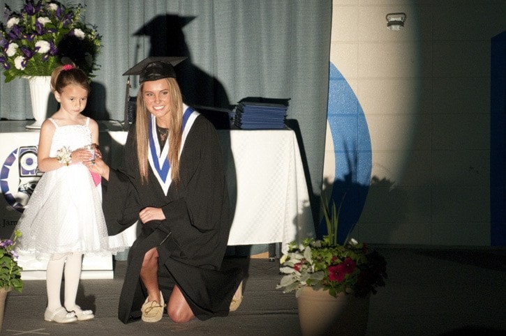 Ashley St. Jean passes her candle on at the graduation ceremony on June 8.