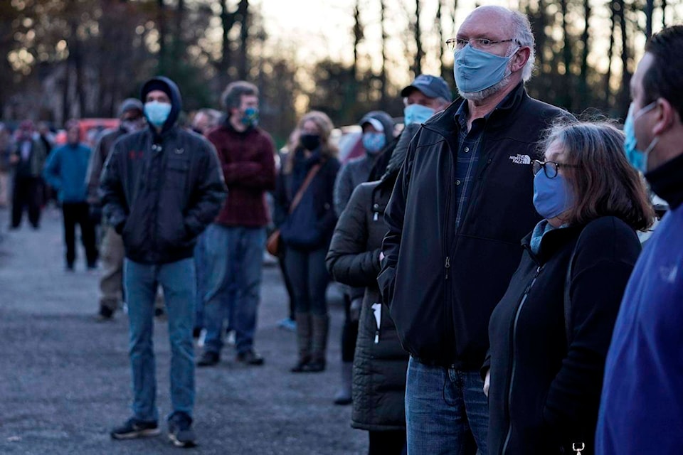 People wait in line to vote at Adam Hall near Auburn Corners, Ohio, Tuesday, Nov. 3, 2020. (AP Photo/Tony Dejak)