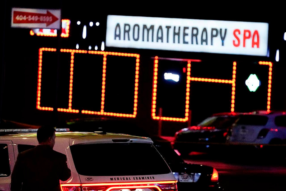 Officials stand in front of a massage parlor after a shooting, Tuesday, March 16, 2021, in Atlanta. Shootings at two massage parlors in Atlanta and one in the suburbs left multiple people dead, many of them women of Asian descent, authorities said. A 21-year-old man suspected in the shootings was taken into custody in southwest Georgia hours later after a manhunt, police said. (AP Photo/Brynn Anderson)