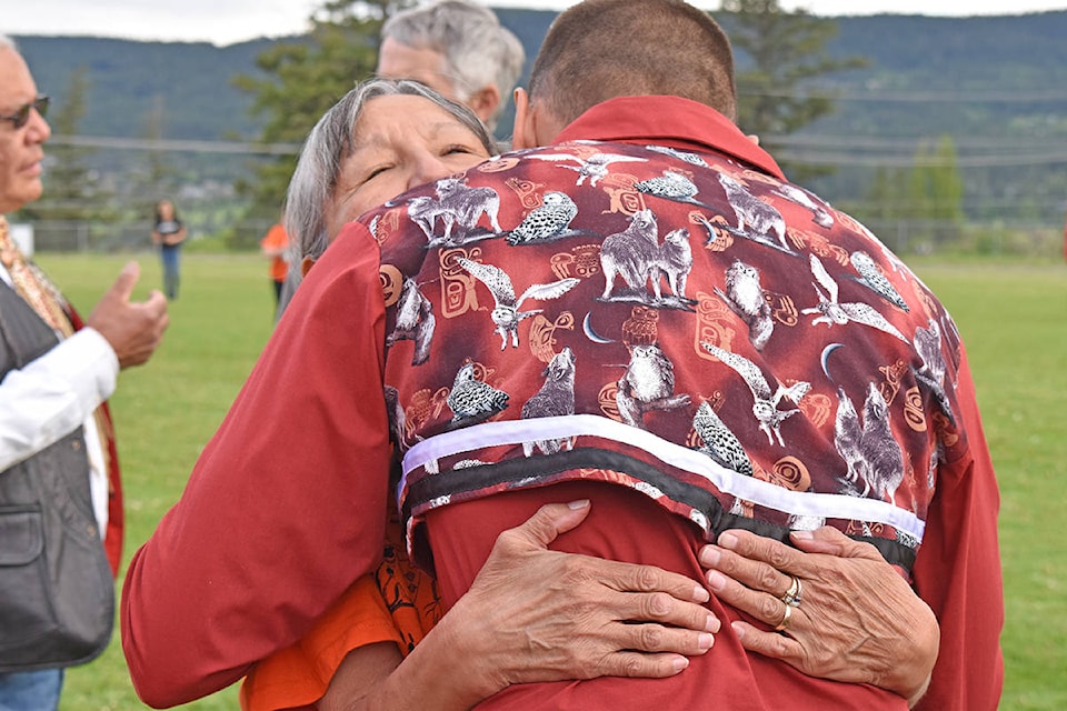 Williams Lake First Nation Chief Willie Sellars shares a hug with Secwépemc elder and residential school survivor, Edith Wycotte following a ceremony in Williams Lake honouring the 215 children. Nak’azdli Whut’en Chief Aileen Prince is encouraging everyone to take care of each other. (Rebecca Dyok photo)