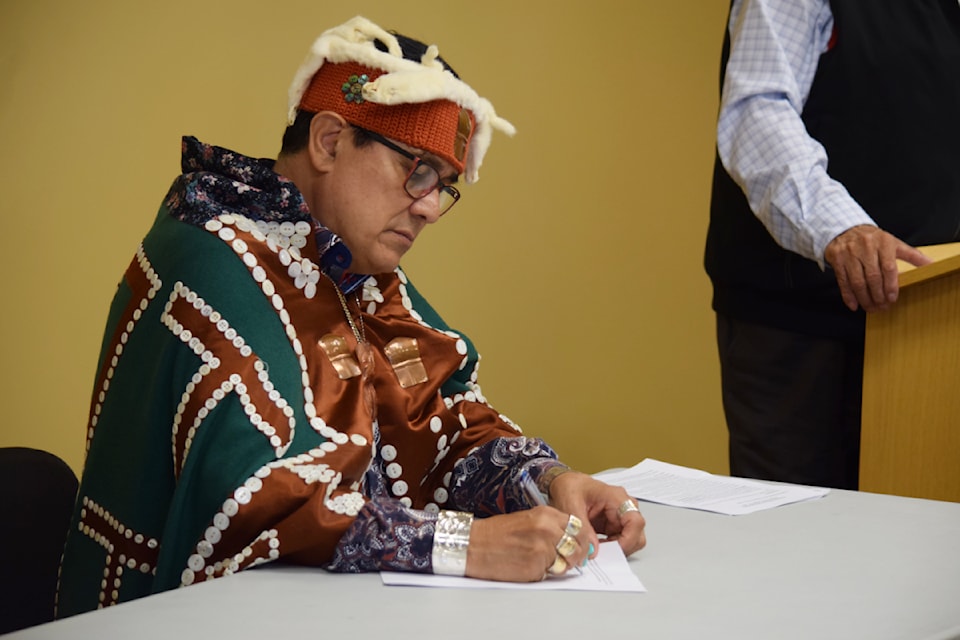Mamalilikulla First Nation Chief John Powell signs the agreement at the Maritime Heritage Centre in Campbell Mirror on Aug. 21.