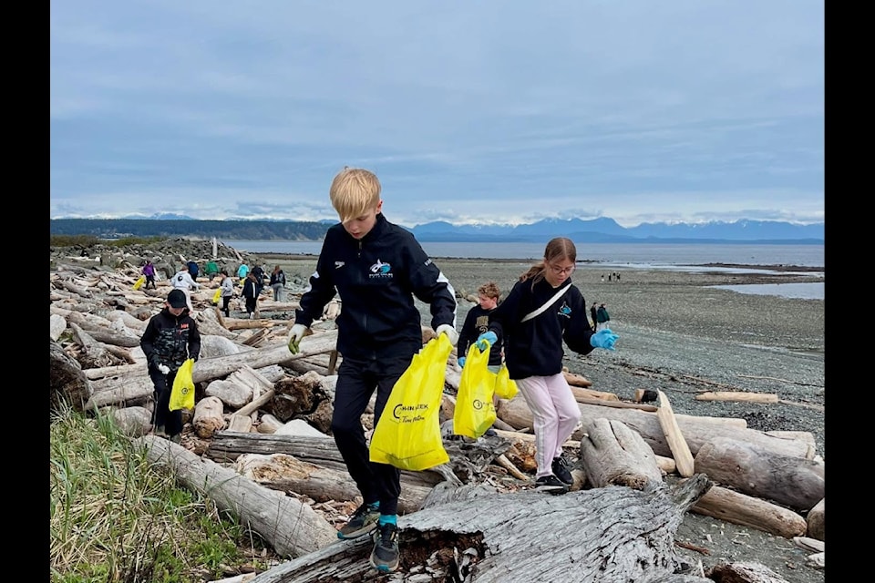 Teammate Alistair Vanjecek helps his crew, the Campbell River Killer Whales Swim Club, clean up debris and garbage at Ken Forde Beach this weekend. The cleanup was part of the Small Planet Cleanup contest, running until April 30 in honour of Earth Month. 