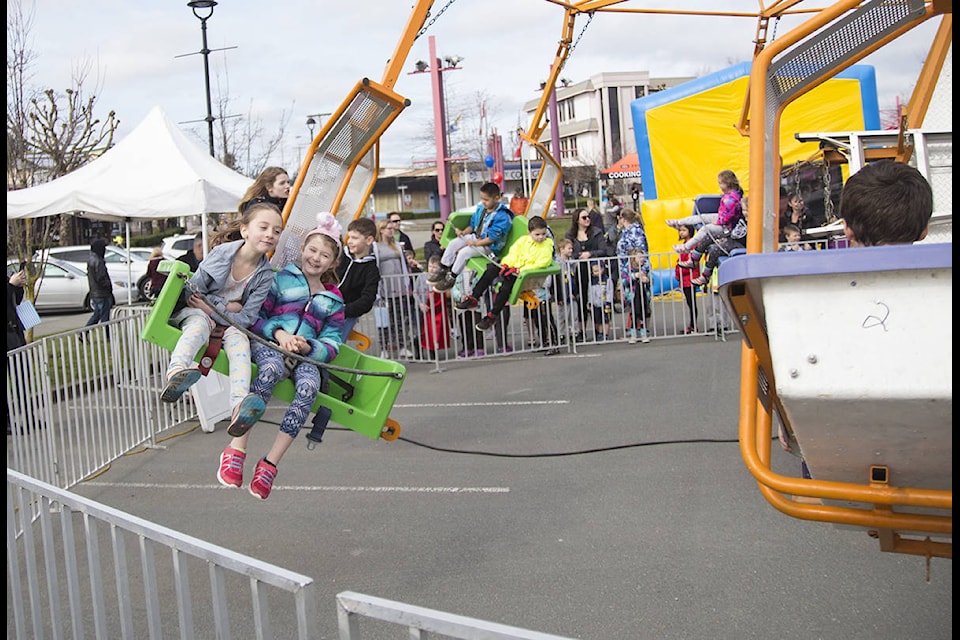 Jayde Hoogenveen and Zoey Lorentz, 7, enjoy a ride set up in Spirit Square for the Easter celebration on Saturday. Photo by Jocelyn Doll/Campbell River Mirror