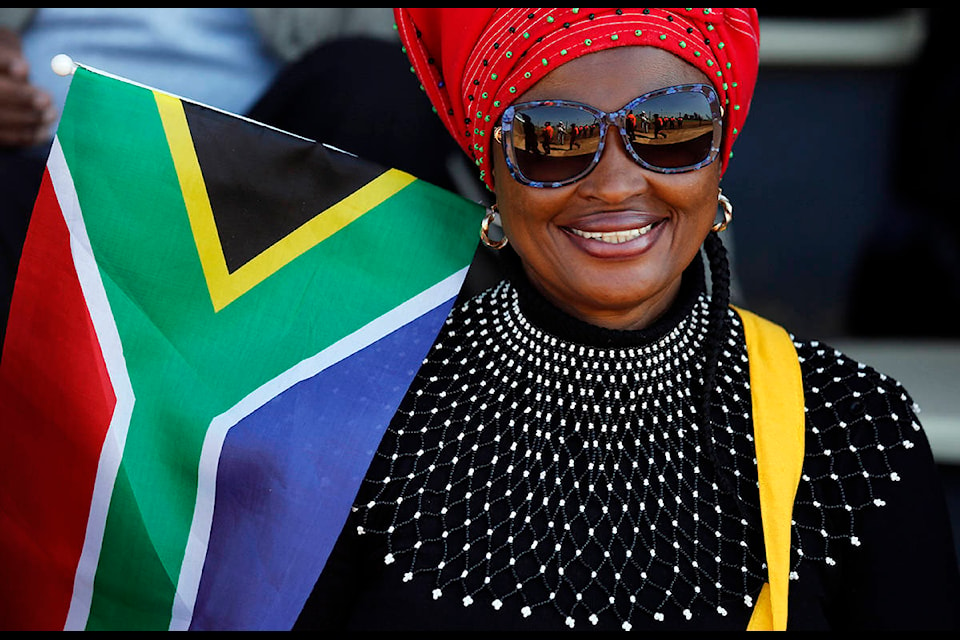 A woman with the South African flag attends Freedom Day celebrations in Kwa-Thema Township, near Johannesburg, Saturday April 27, 2019. Sporting colorful outfits, South Africans celebrate Freedom Day, the holiday marking the 25th anniversary of the end of the brutal system of racial discrimination known as apartheid. (AP Photo/Denis Farrell)