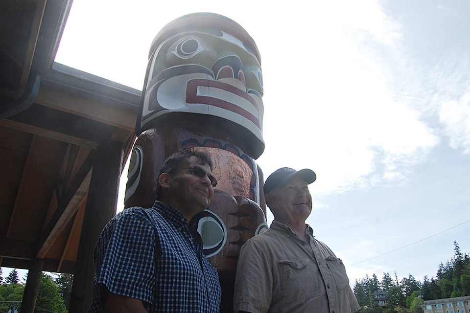 Carvers Bradley Assu (left) and Ted McKellar are shown in front of one of three Welcome Poles newly unveiled at Quathiaski Cove on Quadra Island on June 1, 2019. Photo by David Gordon Koch/Campbell River Mirror