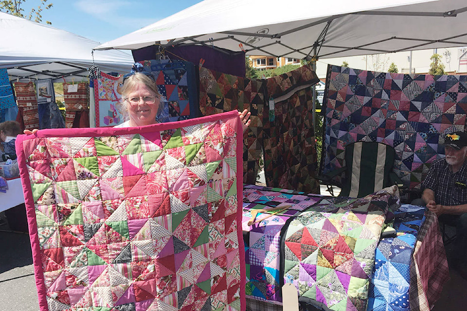 Irene Pel is shown with one of her handcrafted quilts during the Willow Point Summer Market. Photo by David Gordon Koch/Campbell River Mirror