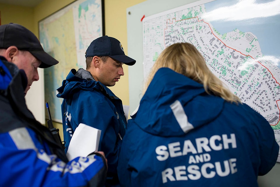 From left, Mike Beattie, Tyler Abbott and Angela Janicki consult a map of the exercise area at their headquarters on Oct. 29, 2019. Campbell River Search and Rescue Members were taking part in an emergency evacuation exercise in the south end of Campbell River, which saw them door-knocking and speaking with members of the community. Photo by Marissa Tiel/Campbell River Mirror