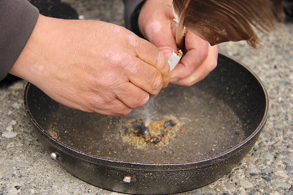 The smell of burning tobacco, sage and cedar fills the air at Centennial Square as people gather to call for action on the missing and murdered Indigenous women and girls crisis. (Jane Skrypnek/News Staff)