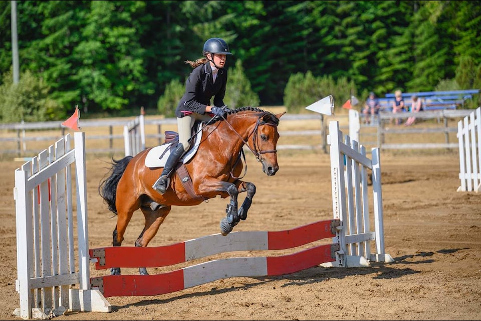 Ainsley Edwards with horse, Maverick, clear a jump during the The Campbell River Trail Riders Association jumper competition on July 10. Photo by Sean Feagan / Campbell River Mirror.