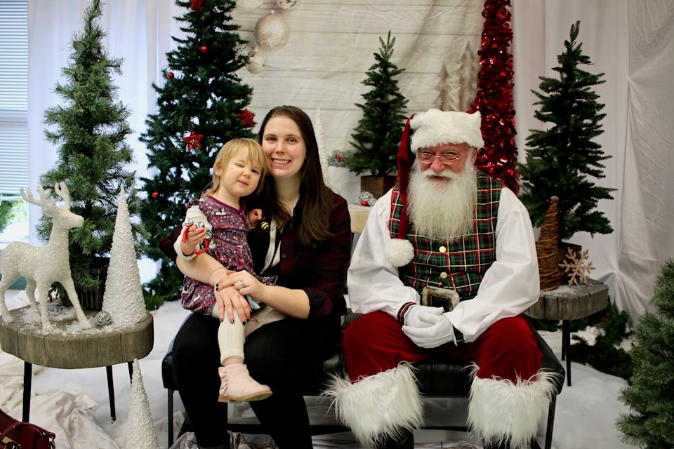 Alice (left) and Laura Selby get their photo taken with Santa. Photo by Marc Kitteringham / Campbell River Mirror