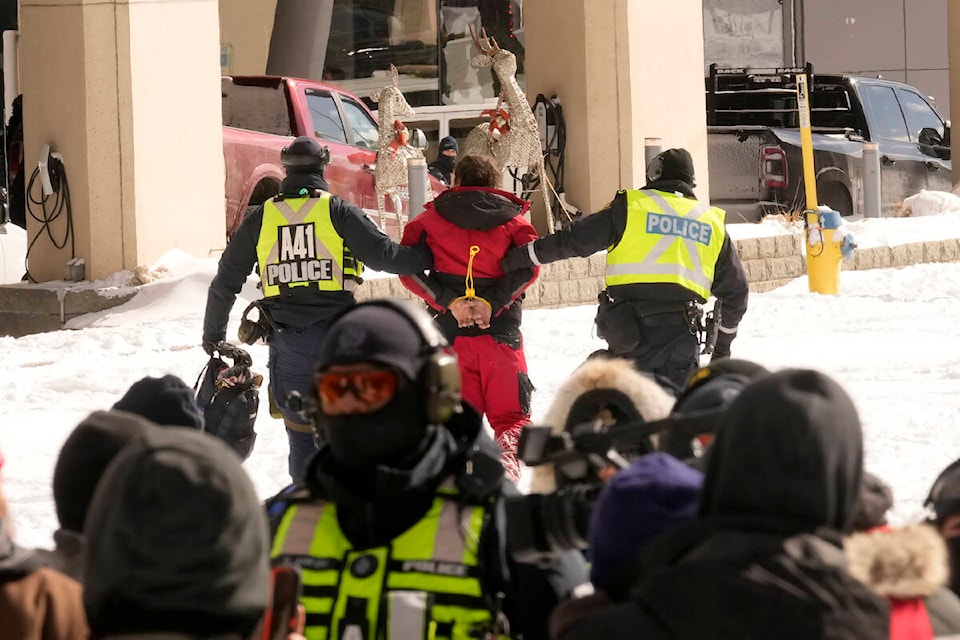 Police make an arrest as they work to bring a protest, which started in opposition to mandatory COVID-19 vaccine mandates and grew into a broader anti-government demonstration and occupation, to an end, in Ottawa, Friday, Feb. 18, 2022. THE CANADIAN PRESS/Adrian Wyld