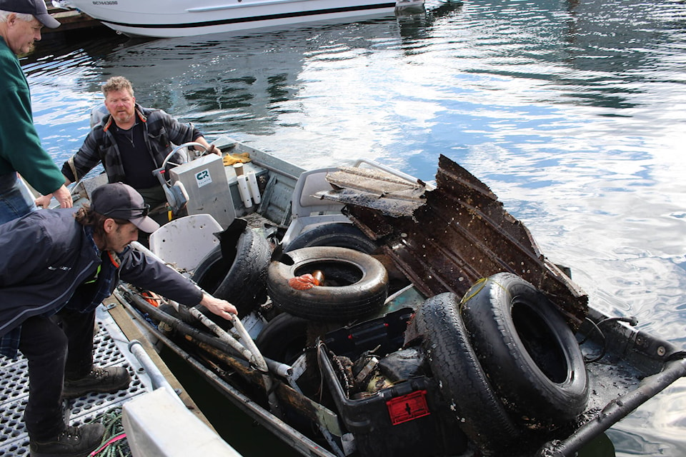 Phil Griffith is helped by volunteers to unload trash from his boat. Photo by Marc Kitteringham/Campbell River Mirror