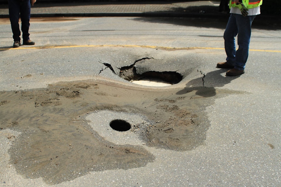 A worker stands near a hole that opened up on the road surface on 10 avenue on Tuesday afternoon. Photo courtesy Ryan Dawson