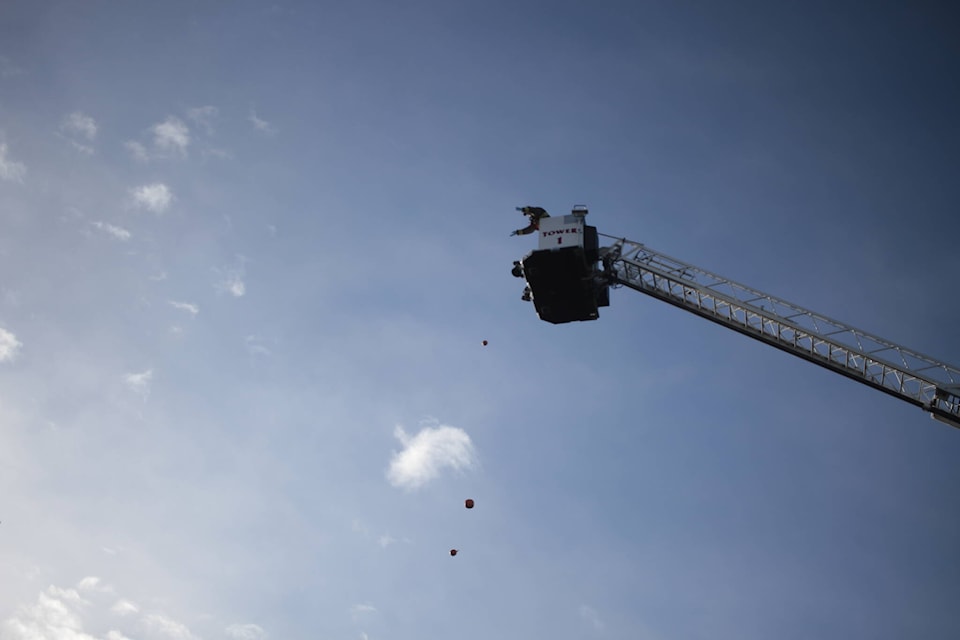 Fire fighter Shawn Kotscherofski drops a few pumpkins from the Campbell River Fire Department’s tower truck. Photo by Marc Kitteringham/Campbell River Mirror