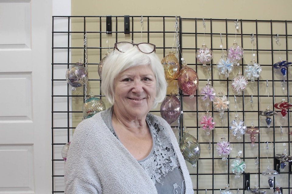 Charlotte Deptford poses with some of her handmade glass ornaments at Sybil Andrews Cottage on Friday afternoon. Photo by Marc Kitteringham/Campbell River Mirror