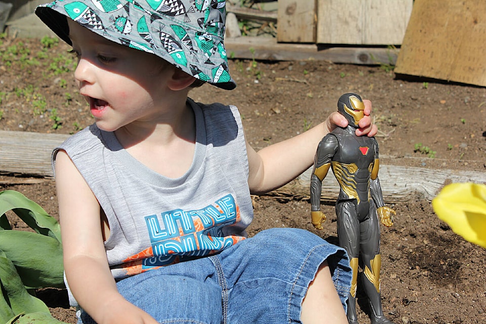 Milo Judd plays in the family’s garden, holding a toy that matched the size of his body when he was born. (Connor McDowell/Comox Valley Record)