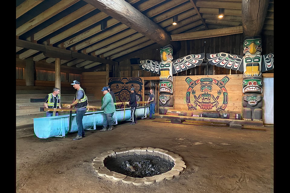 K’ómoks First Nation Guardians, Archaeologists, Royal BC Museum and ̨MM Transportation Solutions collaborators move the panel out of the KFN Big House to its new temporary home at the VIU Deep Bay Marine Field Station.