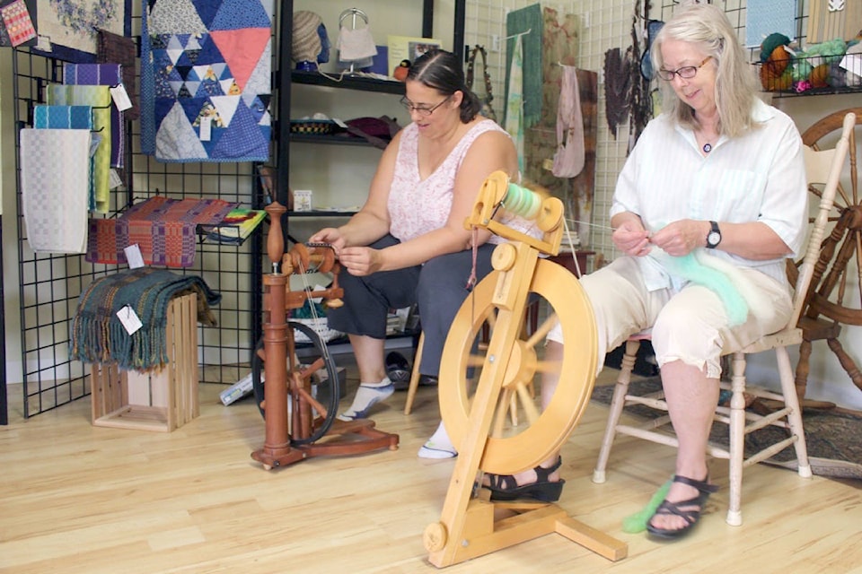 Deborah Johnson and Sandra Donohue of the Selkirk Weavers’ and Spinners’ Guild spun wool in the guild’s room at the Doukhobor Discovery Centre. (Chelsea Novak/Castlegar News file)