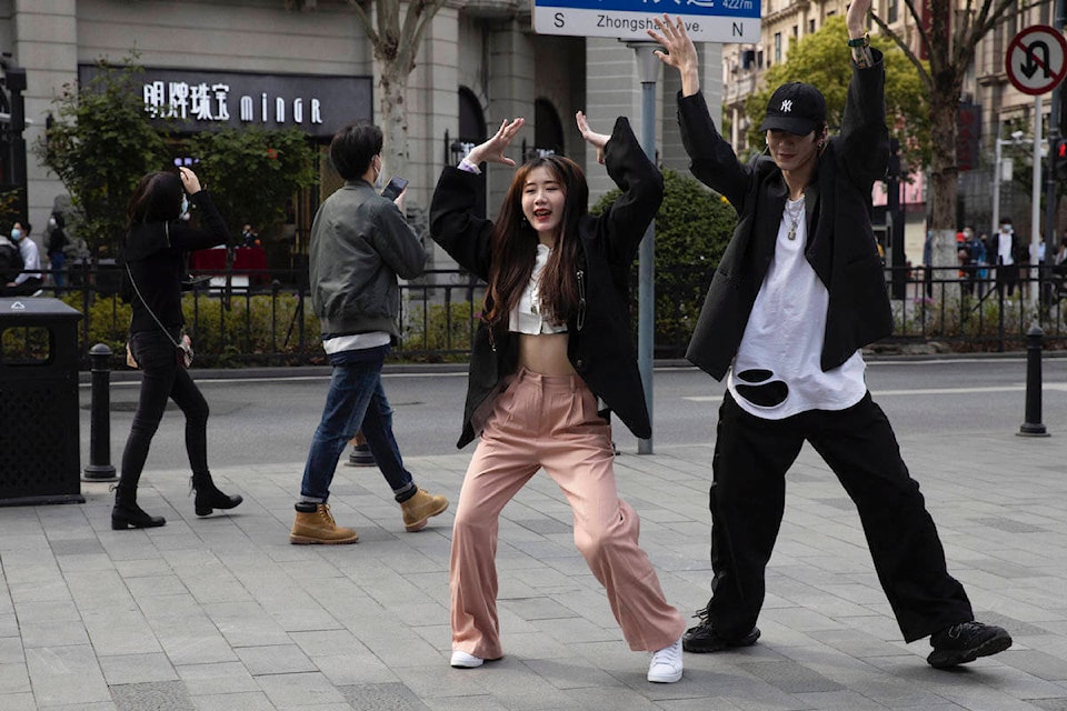 Chinese youths record a dance routine on the streets of Wuhan in central China’s Hubei province on Wednesday, April 8, 2020. Streets in the city of 11 million people were clogged with traffic and long lines formed at the airport, train and bus stations as thousands streamed out of the city to return to homes and jobs elsewhere. Yellow barriers that had blocked off some streets were gone, although the gates to residential compounds remained guarded. (AP Photo/Ng Han Guan)