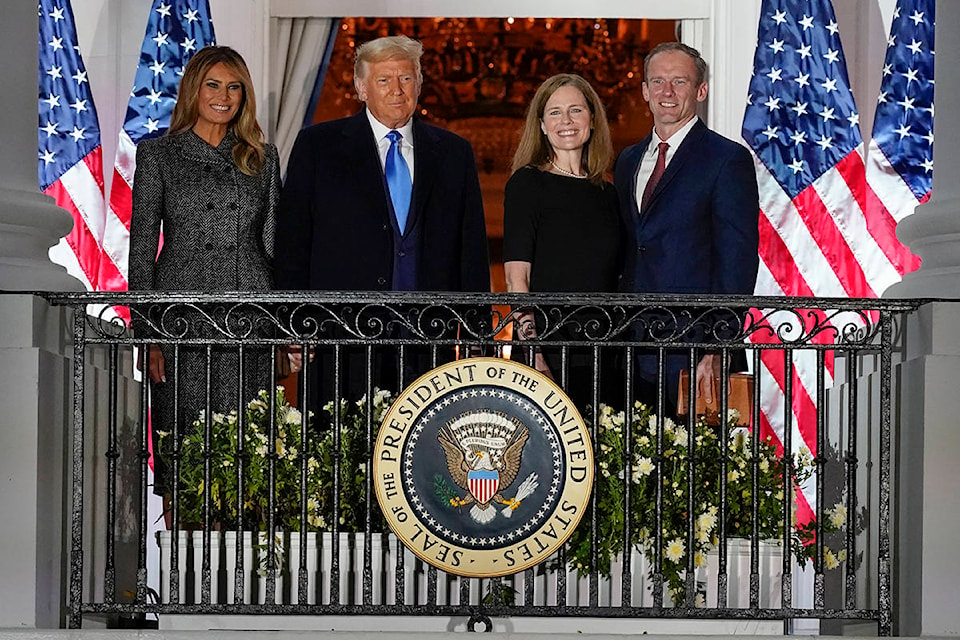 President Donald Trump, first lady Melania Trump, and Amy Coney Barrett and her husband Jesse stand on the Blue Room Balcony after Supreme Court Justice Clarence Thomas administered the Constitutional Oath to her on the South Lawn of the White House White House in Washington, Monday, Oct. 26, 2020. Barrett was confirmed to be a Supreme Court justice by the Senate earlier in the evening. (AP Photo/Alex Brandon)