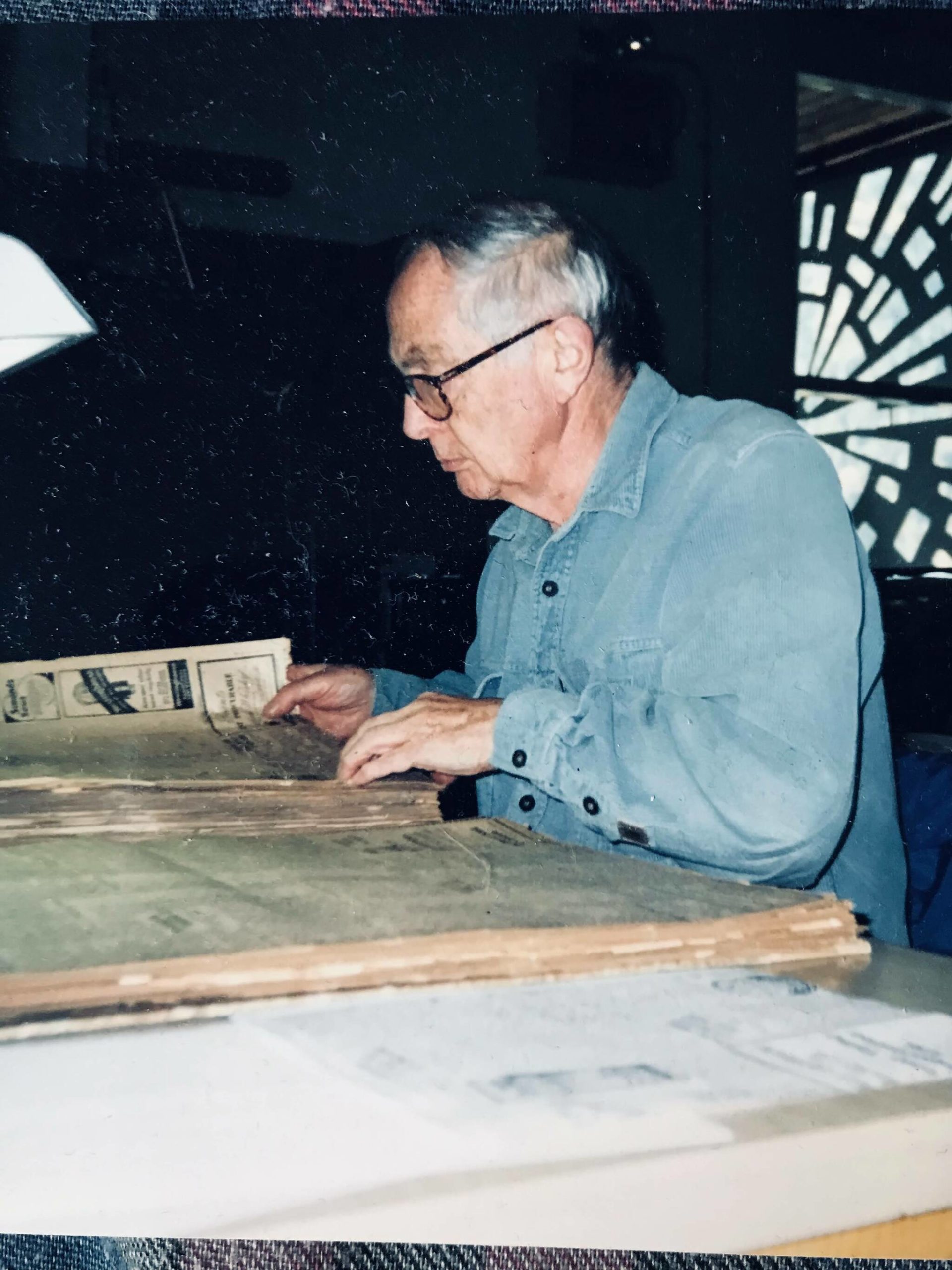 Alan Ramsden combs through the pages of the <em>Nelson Daily News</em> at the old Nelson Museum on Anderson Street, circa 1990s. Photo courtesy of the Ramsden family