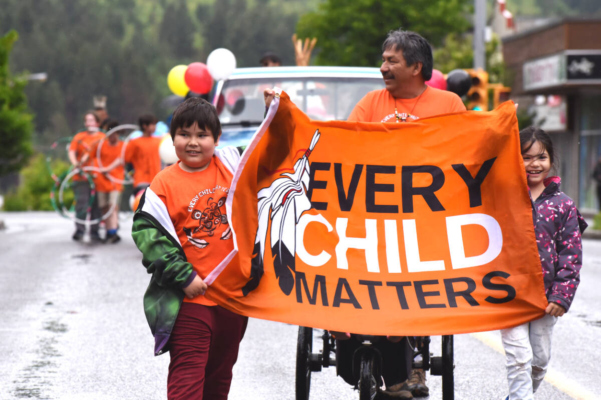 Williams Lake area Austin Summerfeld and Aubree Alexis carry the Every Child Matters banner ahead of Tyman Jobin during the National Indigenous Peoples Day parade in the lakecity in June. (Angie Mindus photo - Williams Lake Tribune)
