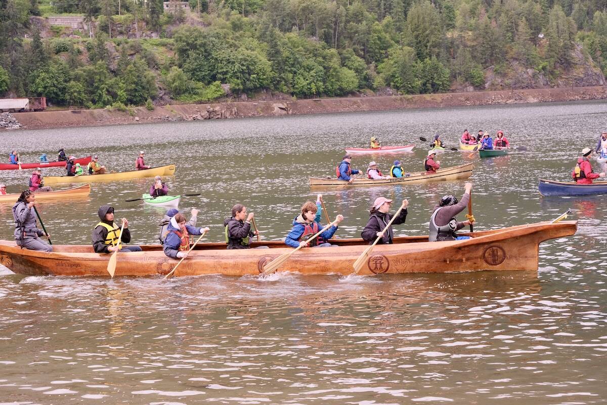 The Sinixt canoe named Coyote Head accompanied by members of the Nelson public, setting out across Kootenay Lake. Photo: Bill Metcalfe