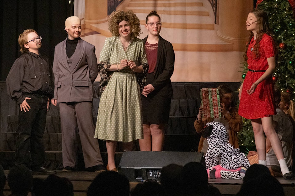 The jig is up; Miss Hannigan (Elizabeth Virgo, green dress), is arrested after trying to scam Mr. Warbucks.