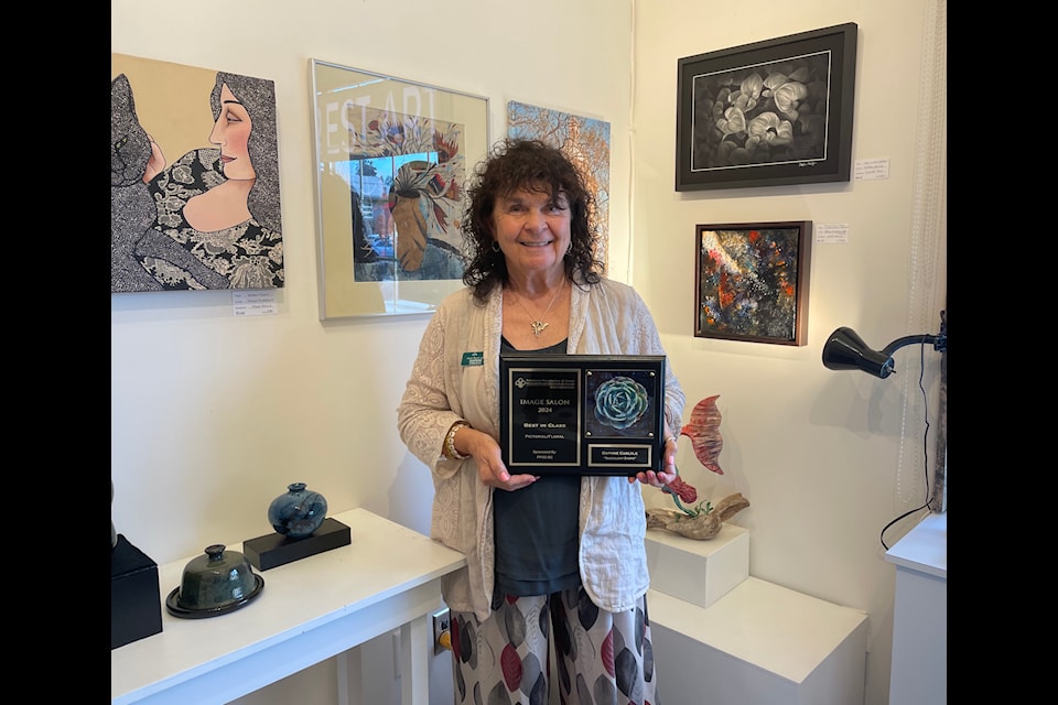 Daphne Carlyle displays her most recent award at Rainforest Arts.