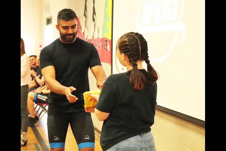 Saanich Police Department Const. Aaron Grewal receives his 2022 Tour de Rock team jersey from Lily Lecinana of Sooke, a childhood cancer survivor and former junior rider. (Don Descoteau/News Staff)