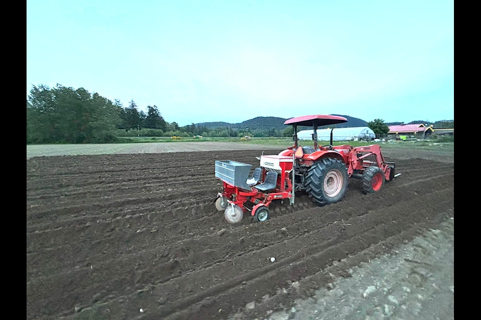 The stolen tractor shown in use before the theft. Jordan Dirom posted this image of the 2004 Kubota working in the field with pallet forks on the front and a potato hiller on the back — the same configuration it had when it was stolen from Valley Roots Farm Market in the early hours of July 7.