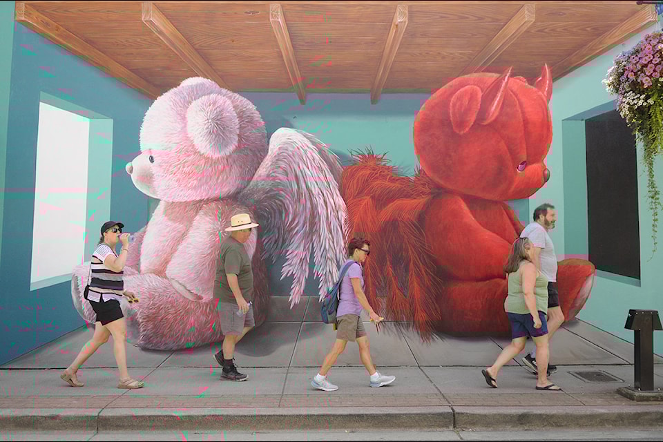 Pedestrians walk past a mural by Leon Keer on Mill Street during the Chilliwack Mural Festival on Saturday, Aug. 17, 2024. 