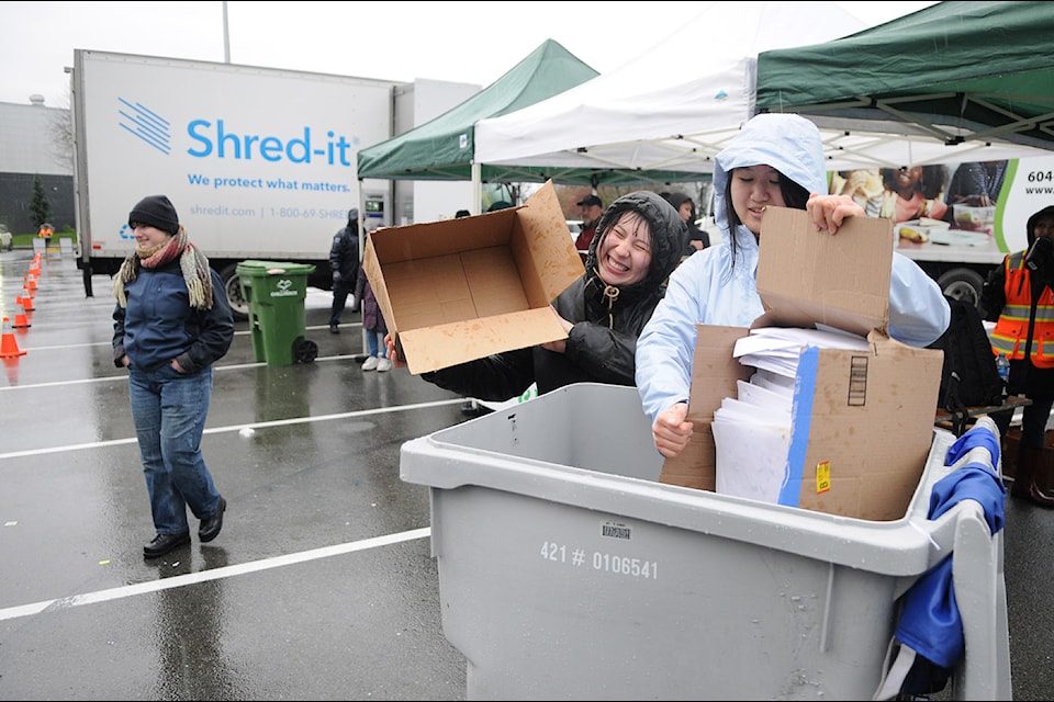 Volunteers help toss boxes of documents into bins before they are destroyed at the City of Chilliwack's Shred-A-Thon outside the Chilliwack Coliseum on Saturday, Dec. 7, 2024.